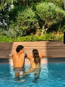 a man and a woman in a swimming pool at Atelier Luma in Zikhron Ya'akov