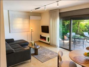 a living room with a couch and a tv and a table at Atelier Luma in Zikhron Ya'akov