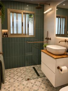 a bathroom with a sink and a shower at Atelier Luma in Zikhron Ya'akov +12 photos