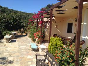 eine Terrasse mit Bänken und Blumen neben einem Gebäude in der Unterkunft Fissi Villas agritourism accommodation near the sea in Agios Nikolaos