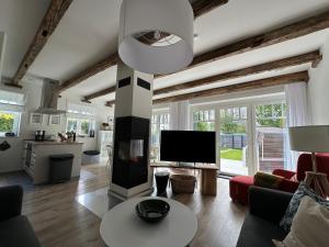a living room with a fireplace and a television at Linnebarg Hus 4 in Fehmarn