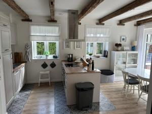a kitchen with white cabinets and a table and chairs at Linnebarg Hus 4 in Fehmarn