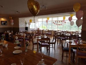 a room filled with tables and chairs with balloons at Ben Loyal Hotel in Tongue