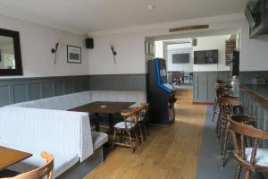 a restaurant with an arcade game and a table and chairs at Ben Loyal Hotel in Tongue