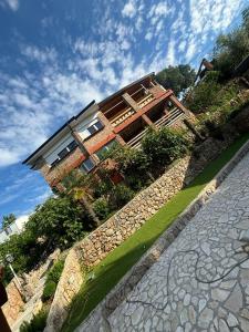 a house on a hill with a stone wall at Jelica in Polje