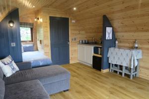 a room with a bed and a kitchen in a log cabin at Ben Loyal Hotel in Tongue
