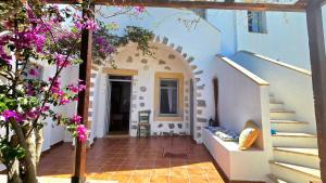 a courtyard of a house with purple flowers at Persephone's Home in Skala