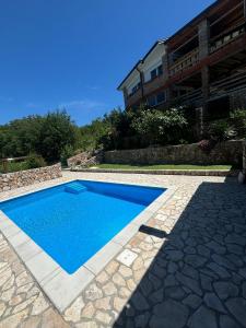 a blue swimming pool in front of a building at Jelica in Polje