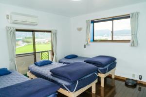 three beds in a room with a window at UMICHIKA AOSHIMA - Private house 一棟貸し in Miyazaki