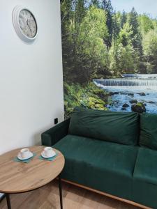 a living room with a green couch and a table at Willa Zuzanna Apartamenty in Ustroń