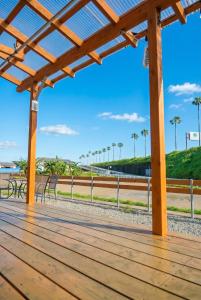 a wooden boardwalk at the beach with benches and palm trees at UMICHIKA AOSHIMA - Private house 一棟貸し in Miyazaki