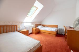 a attic bedroom with two beds and a skylight at Hotel Empire Europe in Prievidza +83 photos