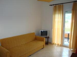 a living room with a couch and a television at Hotel Iliana in Mandrotopos