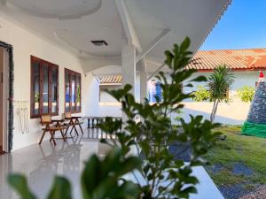 a porch of a house with chairs and a table at Three CoCo Villa AoNang Beach in Ao Nang 