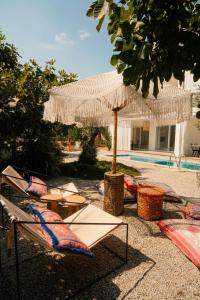 a group of umbrellas and tables next to a pool at Gammi Hayıtbükü in Datca +2 photos