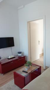 a living room with red furniture and a tv at WING 3 apartman ,,BC ,, in Jagodina