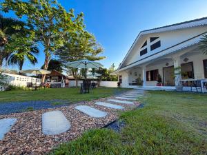 a house with stepping stones in the yard at Three CoCo Villa AoNang Beach in Ao Nang 