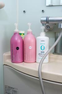 three pink bottles sitting on a shelf in a room at UMICHIKA AOSHIMA - Private house 一棟貸し in Miyazaki +33 photos