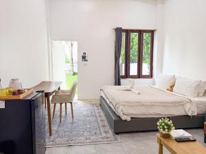 a bedroom with a bed and a desk and a table at Three CoCo Villa AoNang Beach in Ao Nang 