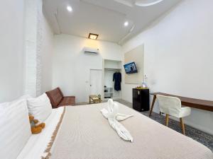 a bedroom with a white bed with a white animal on it at Three CoCo Villa AoNang Beach in Ao Nang  +9 photos