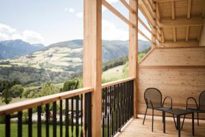 a balcony with two chairs and a view of mountains at Hotel Nussbaumerhof *** in Rodengo
