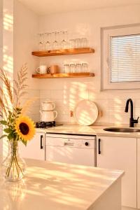 a kitchen with a vase with a sunflower on a counter at Gammi Hayıtbükü in Datca