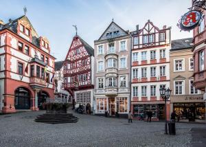 a city street with tall buildings and a clock at Feriengut Bohn in Bernkastel-Kues