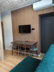 a dining room with a table and a tv on a wall at Willa Zuzanna Apartamenty in Ustroń