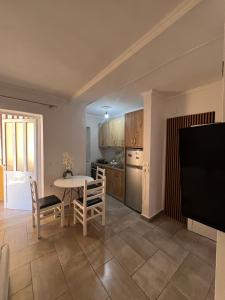 a living room with a table and a kitchen at Bluva rooms Himare in Himare +5 photos