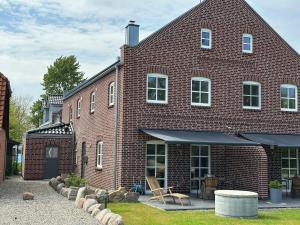 a red brick house with a patio in front of it at Linnebarg Hus 1 in Bisdorf