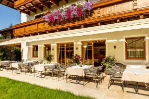 a restaurant with white tables and chairs and flowers at Landhaus Grünau in Wals