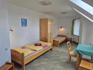 a bedroom with a bed and a chair and a table at Pension Camp Prager in Prague