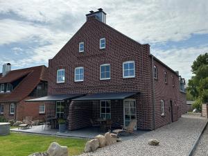 a large red brick building with a roof at Linnebarg Hus 2 in Fehmarn