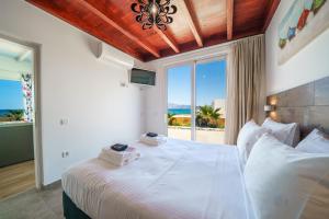 a bedroom with a bed with a view of the ocean at Veranda Sul Mare in Gramvousá