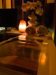 a table with a vase of flowers and a candle at Possidon in Agia Marina Aegina
