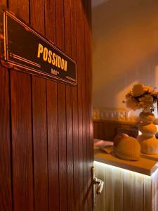 a wooden door with a sign that reads passion inn at Possidon in Agia Marina Aegina