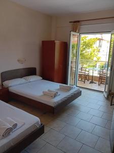 two beds sitting in a room with a balcony at Pfaffenhofen in Nea Vrasna