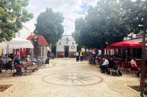 a group of people sitting at tables in a courtyard at Casa Flora Tiny House in Fuzeta