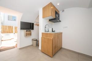 a kitchen with a sink and a counter top at Casa Flora Tiny House in Fuzeta