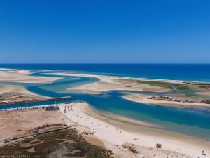 an aerial view of a beach with people in the water at Casa Flora Tiny House in Fuzeta +3 photos
