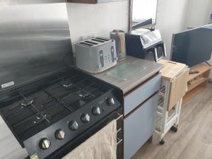 a kitchen with a stove and a appliance on a counter at Skipper's Place in Mortehoe