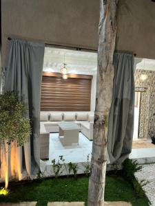 a living room with a couch and a tree at villa privée ghmat in Marrakesh