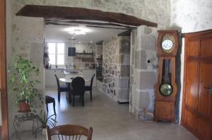 a kitchen and dining room with a clock in a room at Le Clos Cecile'Ann in Fréchou