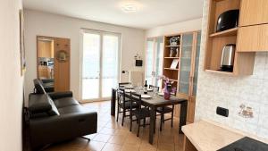 a kitchen and living room with a table and a couch at Casa Enea Exclusive Relax Stay in Colico