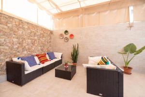 a living room with two couches and a brick wall at Casa flor del Rocio in La Rinconada
