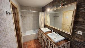 a bathroom with two sinks and a mirror at El Bosque de la Herrezuela in Guisando +48 photos