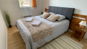 a bedroom with a bed with two towels on it at Gîte du bosquet in Égletons