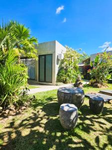 a garden with three stone seats in the grass at Widji Garden Villa in Uluwatu
