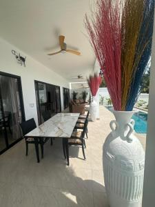 a dining room with a table and a vase with plants in it at AVANA Villa in Nathon Bay
