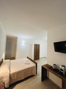 a bedroom with a bed and a flat screen tv at Foresteria Lombarda Pavia in Pavia